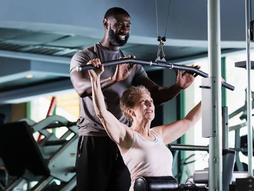 Instructor guiding a client through a strength exercise